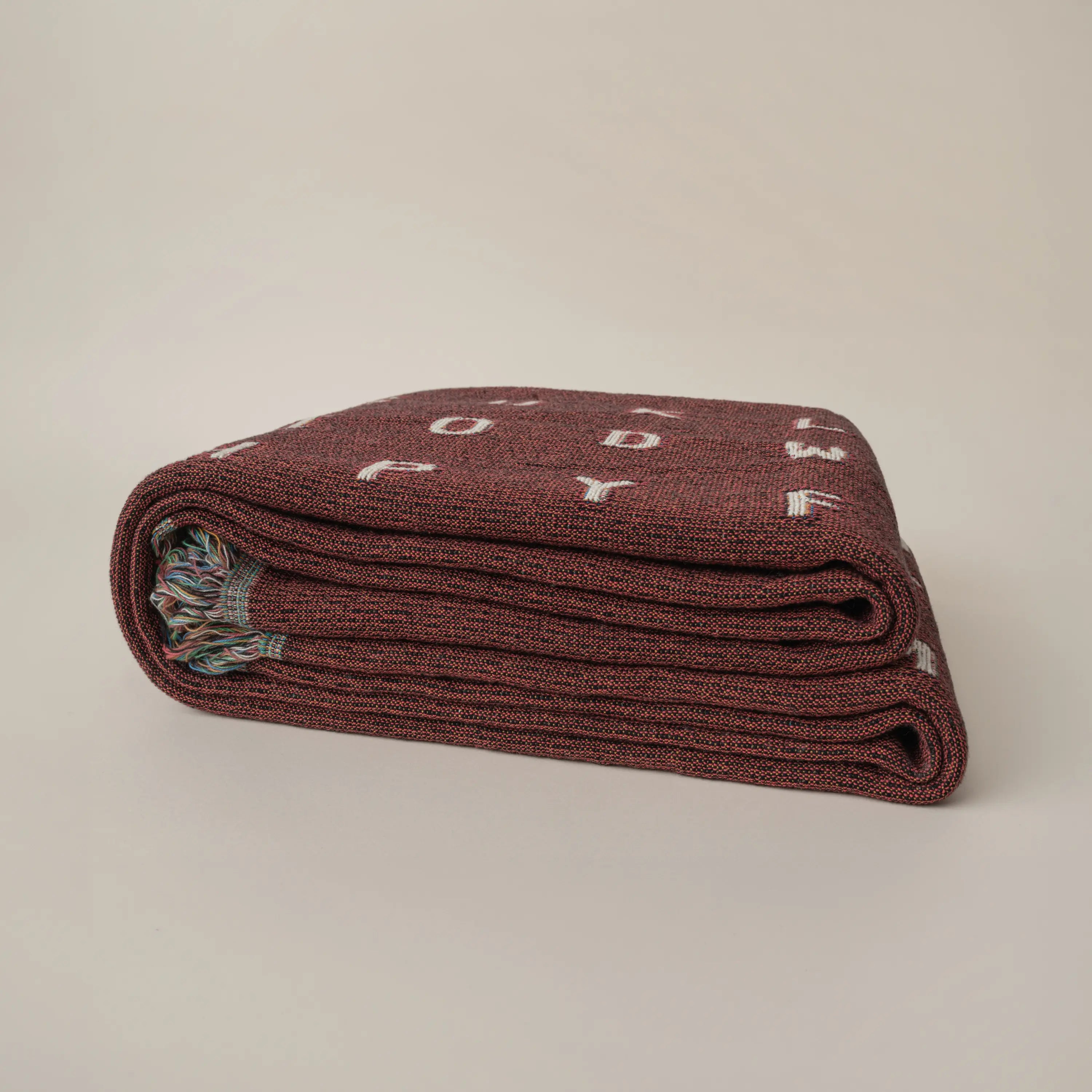 Love — No. 01 in Garnet, folded, with partial letters visible across the cotton weave. #color_garnet